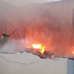 Petugas saat berusaha memadamkan kobaran api yang menghanguskan gudang kasur busa di Sidoarjo.