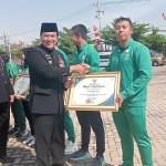 Pj. Bupati Pasuruan Nurkholis saat memberikan penghargaan secara simbolis didampingi Asisten 1 Diano Velaferi.