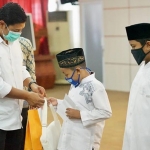 Wali Kota Kediri Abdullah Abu Bakar saat menyerahkan beasiswa pendidikan kepada salah satu anak yatim. (foto: ist)