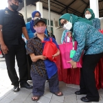 Ketua TP PKK Surabaya Rini Indriyani menyerahkan bingkisan kepada seorang penyandang disabilitas usai divaksin.