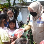 Bupati Mojokerto membagikan bantuan kepada anak-anak warga Mojoanyar korban terjangan angin puting beliung. (foto: ist)