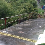 Petugas memasang police line di sekitar jembatan yang roboh dan mensterilkan area karena berbahaya bagi warga. (foto: ist)