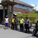 Warga dan petugas saat menutup akses Jalan menuju rumah duka Alm. dr. Suharno, di RT 01/RW 02 Desa Ngadiluwih, Kecamatan Ngadiluwih. (foto: ist)