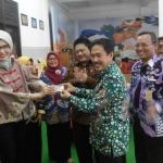 TAKJUB: Anggota Komisi X DPR RI Arzetti Bilbina menunjukkan kartu anggota perpustakaan didampingi Wabup H Nur Ahmad Syaifuddin, Jumat (9/12). foto: mustain/ bangsaonline