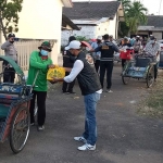 Ratusan tukang becak antre menerima paket sembako dari HDCI dan Polres Madiun Kota.