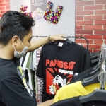 Adiyanto, peraih juara dua dalam kompetisi custom art wear kategori brand lokal saat menunjukkan hasil karyanya. foto: ist.
