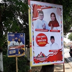 Banner Dhito-Dewi yang ada foto Ir. H. Sutrisno, M.M., yang ditempel dengan menutup gambar lain, yaitu banner milik Golkar di Jalan Raya Kediri-Pare Kecamatan Gurah, Kabupaten Kediri. (foto: MUJI H/ BANGSAONLINE)
