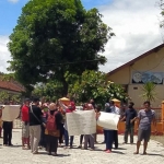 Puluhan warga yang tinggal di Jalan Astrokoro Tambak Bayan Kecamatan Ponorogo menggelar aksi protes di depan SMA PGRI 1 Ponorogo lantaran tak terima jika sekolah tersebut akan dijadikan shelter Covid-19, Selasa (6/10/2020). (foto: ist).