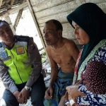 Bripka Purnomo, Bhabinkamtibmas Kecamatan Babat berbincang dengan penerima bantuan.