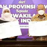 Gubernur Jawa Timur Khofifah Indar Parawansa dan Ketua DPD RI La Nyala Mahmud Mattalitti menunjukkan dokumen serah terima tanah hibah di Gedung Negara Grahadi Surabaya, Senin (7/3/22).