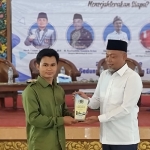 H. Syafiuddin, S.Sos. saat menerima cenderamata dari Mahmud Ismail, Ketua PWI Bangkalan.