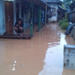 Akibat tanggul sungai jebol, aktivitas warga terganggu karena aliran air yang masuk menggenangi permukiman warga. Foto: Arif Kurniawan/BANGSAONLINE