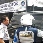 Kabid Parkir Dishub Kota Malang Syamsul Arifin saat memperingatkan pemilik showroom Kedawung Motor agar memindahkan mobilnya. foto: IWAN I/BANGSAONLINE