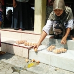 Beberapa warga penerima, seperti Siti Nutavia (39), curiga dan mengecek kondisi telur dengan memecah satu butir telur.