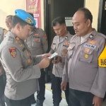 Kasipropam AKP Darsono saat melakukan pengecekan ponsel milik anggota Polsek