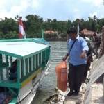 Petugas saat menaikkan naskah Unas ke perahu. foto: rahmatullah/ BANGSAONLINE