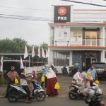 Pengurus DPC PKS Kabupaten Mojokerto sedang bagi-bagi takjil ke para pengendara motor yang melintas. di depan kantor.