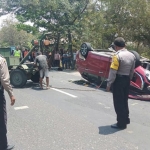 Petugas saat berupaya mengevakuasi Mitsubishi XPander yang terbalik.