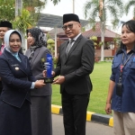 Wali Kota Mojokerto, Ika Puspita Sari saat menyerahkan penghargaan kepada Agung Moeljono Soebagijo, Kepala Dinas Pendidikan dan Kebudayaan