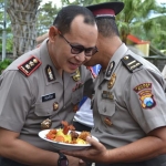 Kapolres Batu AKBP Harviadhi Agung Prathama menyerahkan potongan tumpeng kepada Ipda Suratno usai prosesi kenaikan pangkat, Senin (2/3).