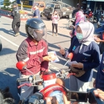 Petugas Dinkes Ngawi saat membagi-bagikan masker gratis di Perempatan Kartonyono.