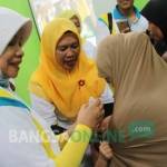 Bupati Kediri dr. Hj. Haryanti Sutrisno saat memberikan imunisasi kepada balita yang hadir, dengan didampingi sang ibu di Balai Desa Kerkep Kecamatan Gurah Kabupaten Kediri.