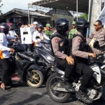 Petugas KPPS 10 Desa Dahanrejo Kebomas mendapat kawalan polisi saat mengantar logistik Pemilu ke PPK Kebomas. foto: SYUHUD/ BANGSAONLINE