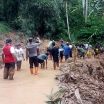 Warga Desa Hargosari bersama anggota Polsek dan Koramil Sine melakukan kerja bakti bersih-bersih longsoran tanah.