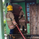 Petugas saat memadamkan api yang membakar sebuah rumah di Desa Mlati, Kecamatan Mojo, Kabupaten Kediri.