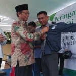 Bupati Tuban Fathul Huda memakaikan jaket kepada kurir RSUD Dr. Koesma yang akan bertugas mengantar obat.