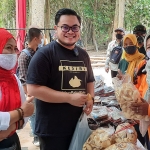 Dhito saat disodori kerupuk oleh ibu-ibu pelaku UMKM di area Sumber Putriman Dusun Mantren. Karena harus icip-icip, maka Dhito harus melepas maskernya. (foto: MUJI HARJITA/ BANGSAONLINE)