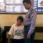 Tri saat didampingi petugas Polsekta Nganjuk saat akan menjalani interogasi. foto: Soewandito/BangsaOnline.com