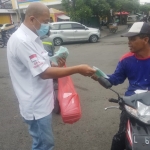 PSI Kota Surabaya membagikan masker dan nasi kotak kepada warga yang melintas di jalan.