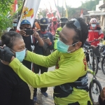 Wabup Qosim saat memakaikan masker kepada salah satu warga. foto: SYUHUD/BANGSAONLINE