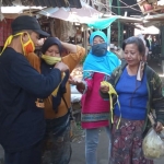 Relawan Laskar Sri Aji Joyoboyo, saat membagikan masker kepada pedagang pasar. foto: ist.