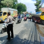 Petugas kepolisian saat mengevakuasi truk tangki air yang mengalami rem blong di Jalan Raya A Yani Sidoarjo.