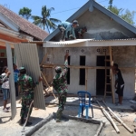 Satgas TMMD Kodim 0818 dibantu warga memasang asbes di rumah Riyono.