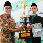 Bupati Pamekasan Baddrut Tamam saat menyerahkan trofi juara saat penutupan MTQ ke XXIX tingkat Kabupaten Pamekasan.