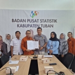Kepala BPS Tuban, Andhie Surya Mustari dan Ketua PWI Tuban, Suwandi (tengah) seusai melakukan penandatangan berkas hasil FGD