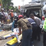 Petugas dan warga sekitar kejadian sedang mengevakuasi korban.