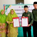 Andi Fajar Yulianto (dua dari kanan) didampingi Muhlis bersama Ketua PC Muslimat NU Kabupaten Gresik, Hj. Aliyah Ghozali menunjukkan MoU. (Ist)