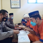 Para tahanan sedang belajar mengaji dalam program Tahjil Ramadan Polda Jatim.