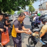 Personel Bag SDM Polres Mojokerto membagikan bubur kacang hijau kepada warga di sekitar Stasiun Mojokerto. (Ist)