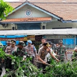 Kapolresta Sidoarjo Kombes Pol Zain Dwi Nugroho ikut membersihkan ranting-ranting pohon usai dipotongi.