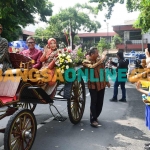 Pj Bupati Heru Suseno melambaikan tangan ke warga yang menonton kirab Hari Jadi Kabupaten Tulugangung ke-819 dari kereta kencana. Foto: Fery Wahyudi/BANGSAONLINE