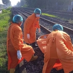 Polisi saat mengevakuasi potongan tubuh korban di perlintasan kereta api.