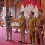 Kepala Dikbud Kota Mojokerto, Ruby Hartoyo, saat menerima penghargaan. 