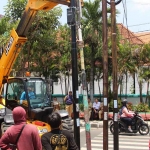 Petugas gabungan dari Pemkab Jombang ketika membongkar 4 tiang internet di perempatan Jalan Pahlawan menuju Jalan KH Wahid Hasyim.