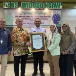 Direktur Teknologi Informasi (TI) BPJS Kesehatan, Eswin Aristiawan memberikan penghargaan kepada kepala RS Widodo Ngawi. Foto: Dok BPJS Kesehatan.
