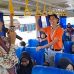 Dua pemandu dari Uniska saat berinteraksi dengan siswi berkebutuhan khusus di dalam Bus Satria.